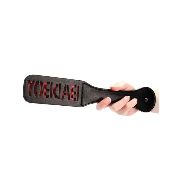 Leather paddle with ’YOEKAI’ cut-out held by hand - Shots Ouch Bad Boy Paddle - Black