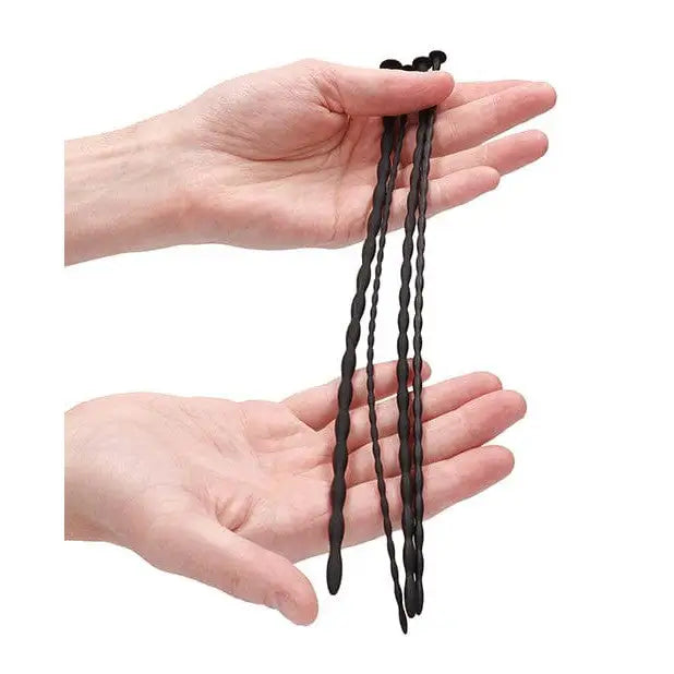 Twisted black silicone anal beads from Shots Ouch Beginner Urethral Sounding Set in hands