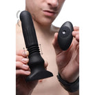 Man holding Silicone Swelling And Thrusting Plug with remote control in hand