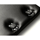 Close-up of Strict Bondage Board’s black leather bag corner with metal buckle fasteners