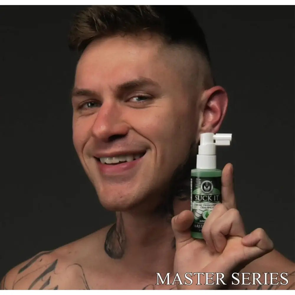 Smiling person with tattoos holding Suck It Throat Desensitizing Oral Sex Spray