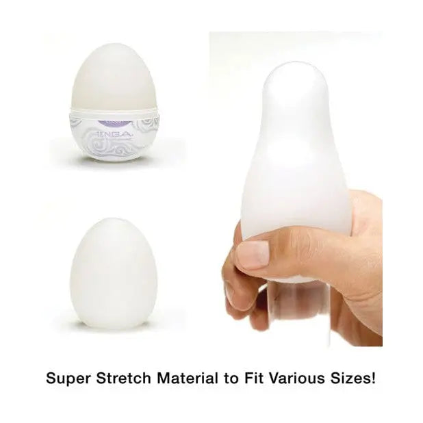 Hand holding Tenga Hard Gel Egg with ’super stretch’ displayed on a white egg