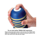 Hand holding the Tenga Premium Original Vacuum Cup, blue-yellow striped with white top