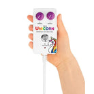 A hand holding a white unicorn earphone for The Unicorn Premium Sex Machine