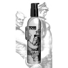 Close up of Tom Of Finland Hybrid Lube- 8 Oz bottle with a man in the background