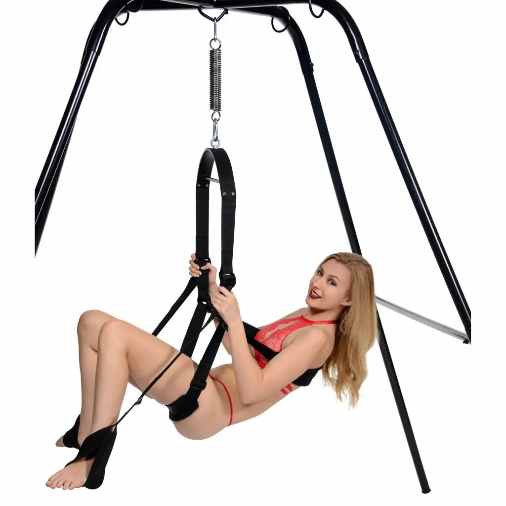 A woman in a red bikini top on the Trinity Vibes Ultimate Sex Swing Stand