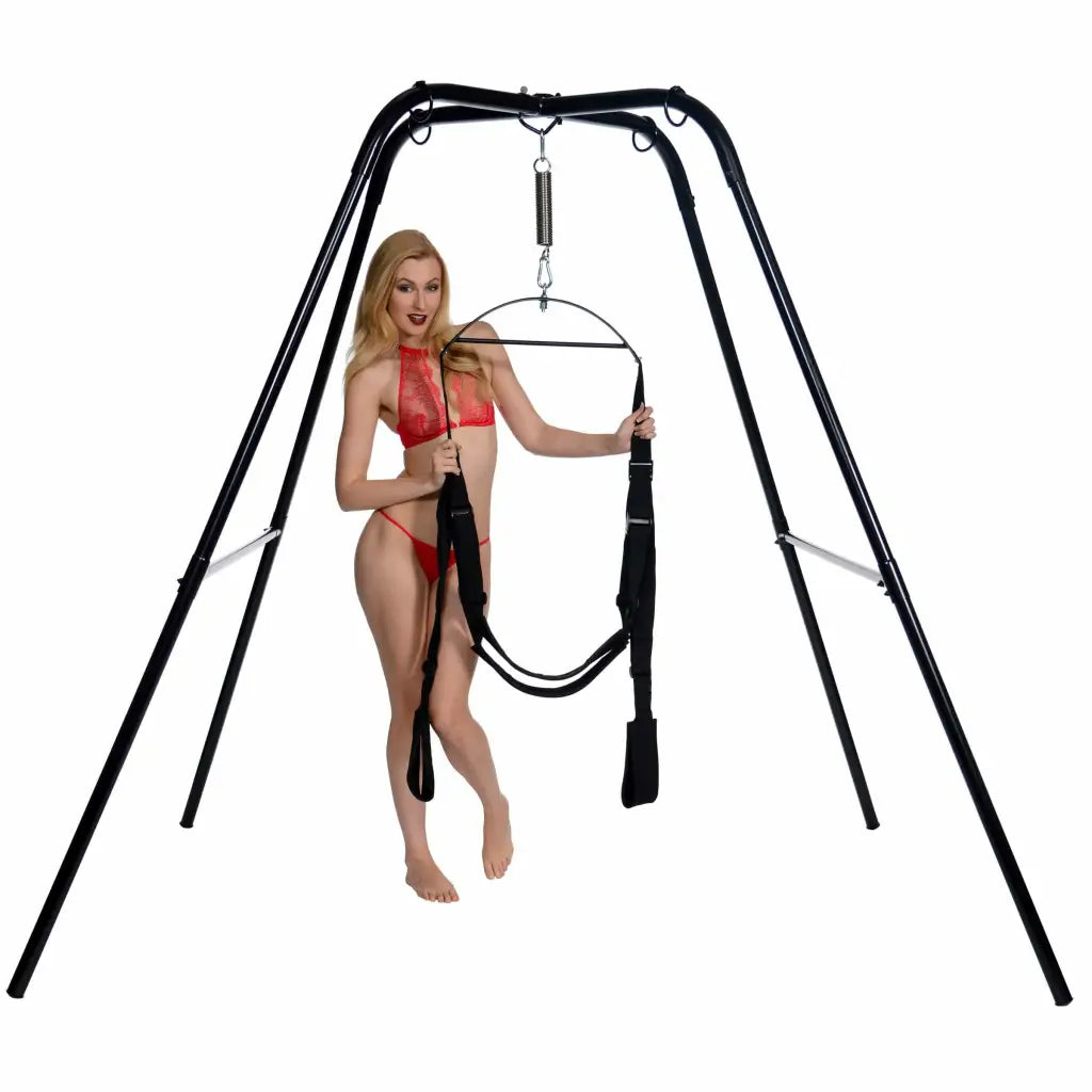 A woman in a red bikini top holding a pole for the Trinity Vibes Ultimate Sex Swing Stand