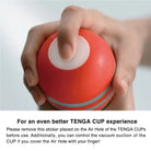 Red original vacuum cup with white top held in hand, U.S TENGA Original Vacuum Cup