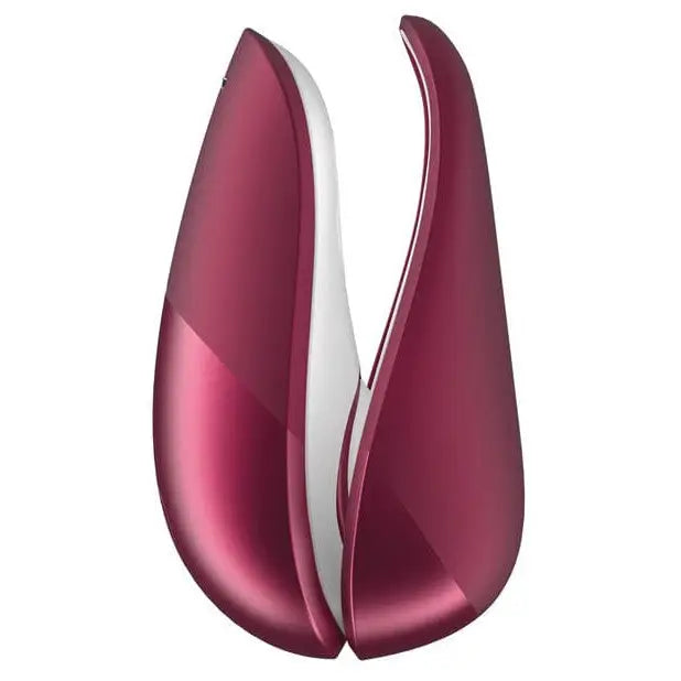 A pair of red and white vases next to the Womanizer LIBERTY Air Clitoral Stimulator