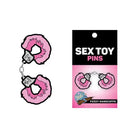 Fuzzy pink handcuffs enamel pin set by Wood Rocket, perfect as sex toy-themed accessories