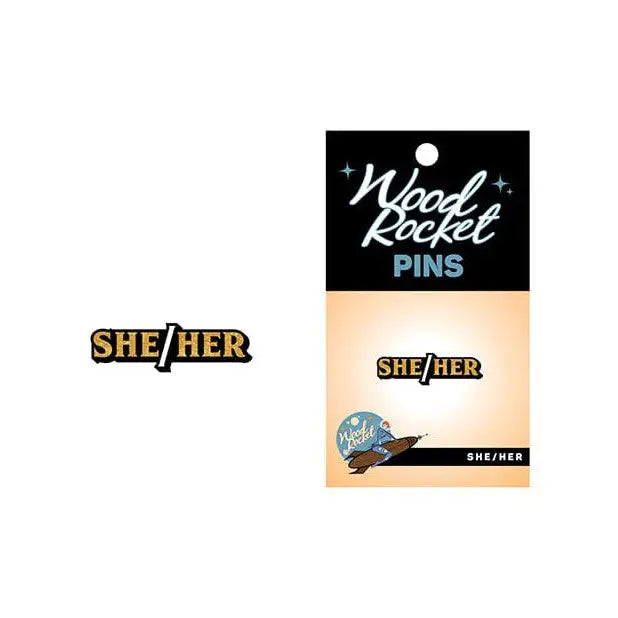 Wood Rocket black and gold enamel pin featuring SHE/HER pronouns